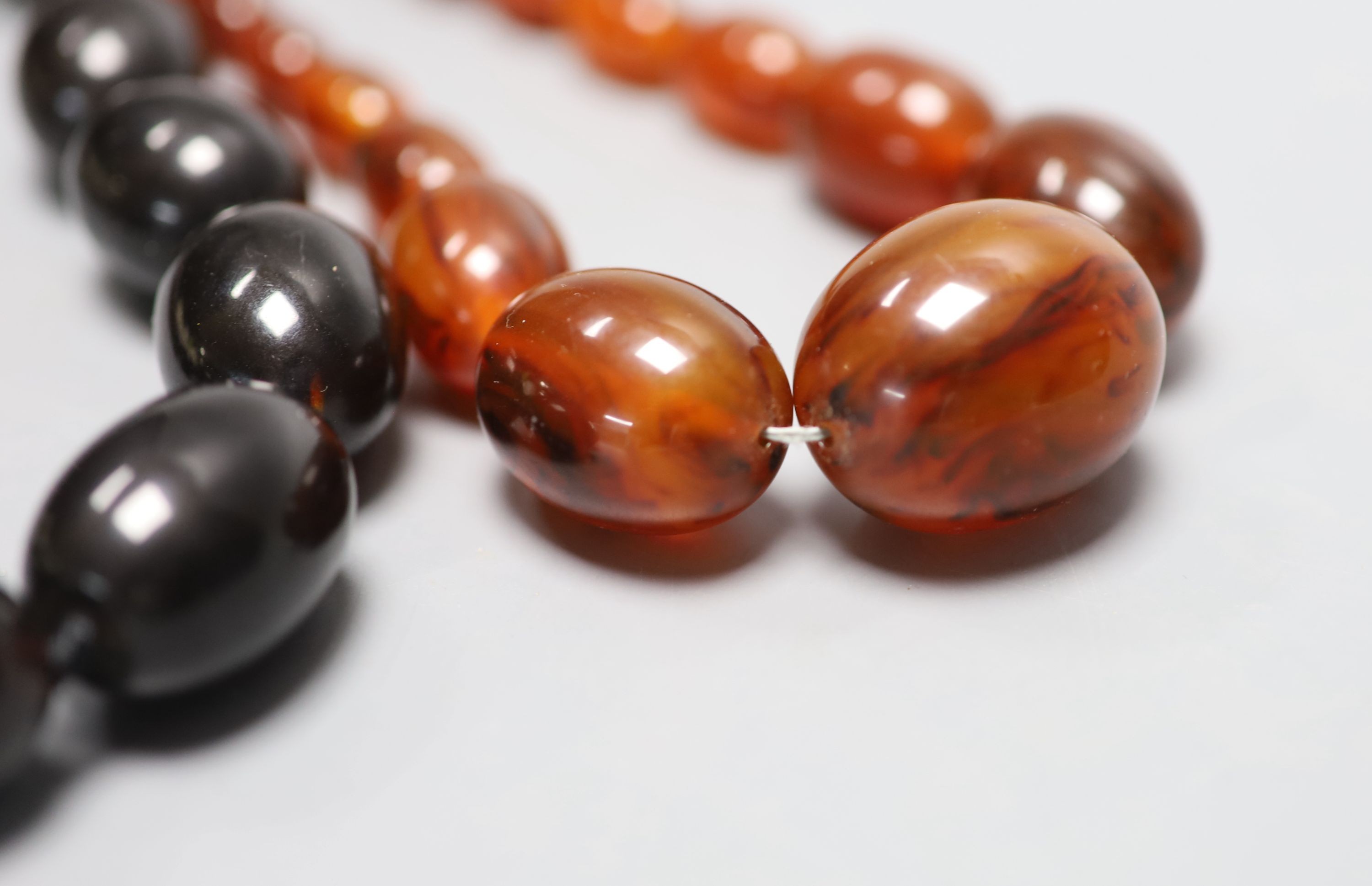 Four assorted simulated amber bead necklaces, largest 62cm.